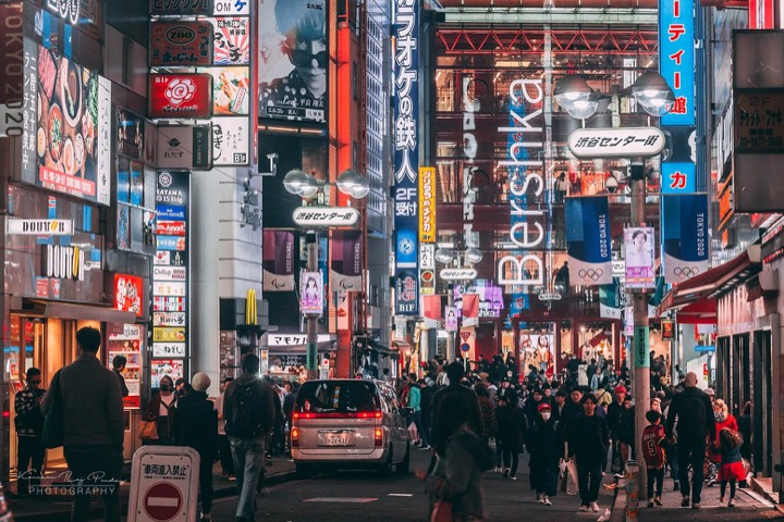 Crowded Shibuya street at night lit by neon signs and billboards, Tokyo